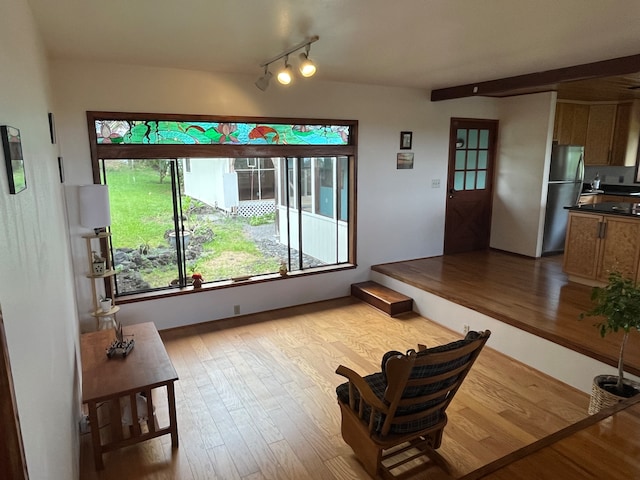 living room with beamed ceiling and light hardwood / wood-style flooring