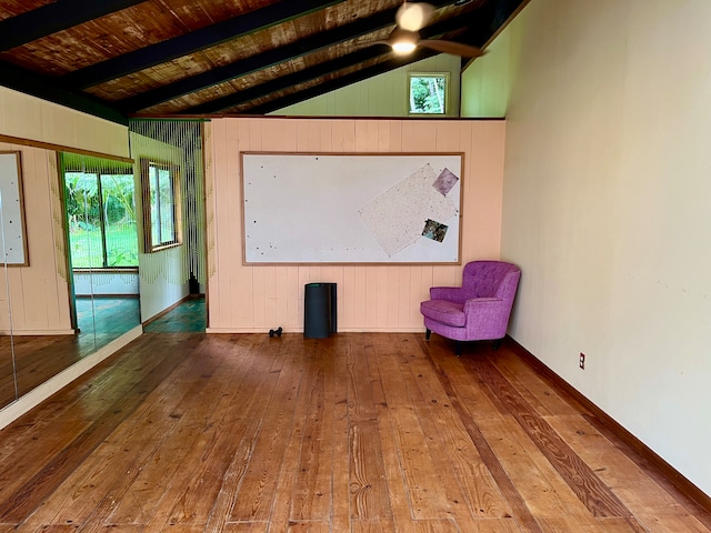 home theater with plenty of natural light, hardwood / wood-style floors, and lofted ceiling with beams