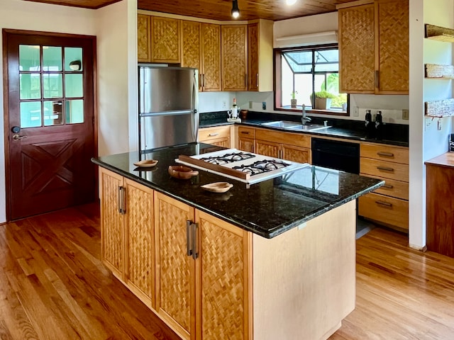 kitchen featuring light hardwood / wood-style flooring, sink, a kitchen island, and stainless steel refrigerator