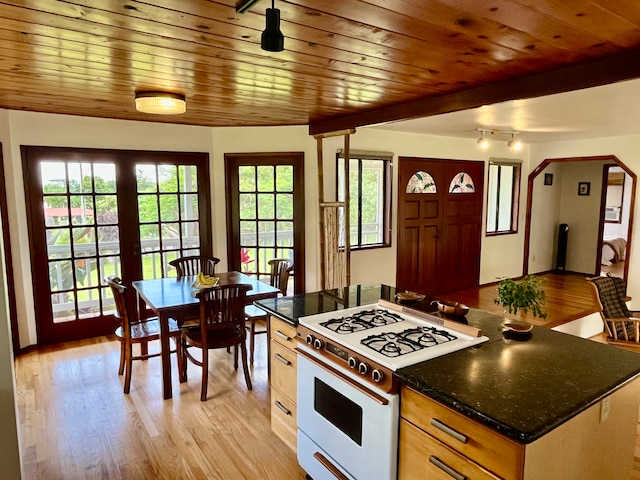 kitchen with light wood-type flooring, beam ceiling, wooden ceiling, and white gas range oven