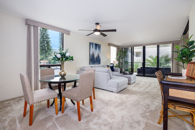 interior space featuring ceiling fan, light colored carpet, and expansive windows