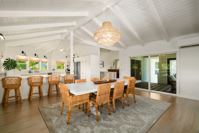 dining room featuring a wall mounted AC, lofted ceiling with beams, hardwood / wood-style floors, and a notable chandelier