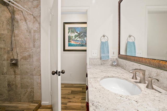 bathroom featuring vanity, tiled shower, and hardwood / wood-style floors