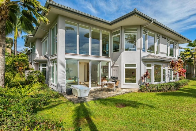 rear view of property with a yard and a patio area