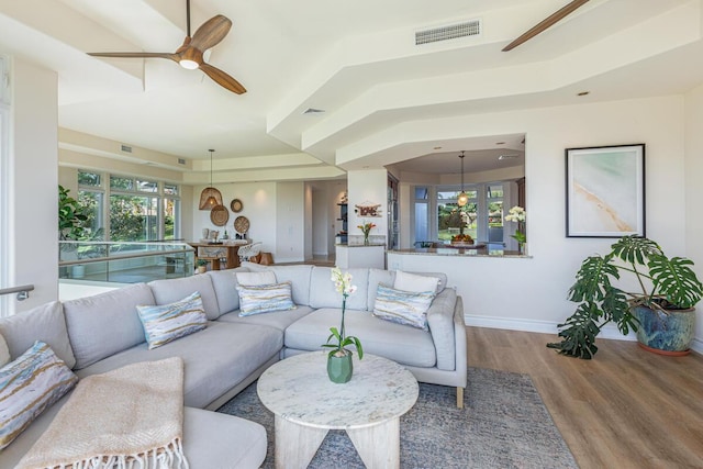 living room with ceiling fan, plenty of natural light, and hardwood / wood-style floors