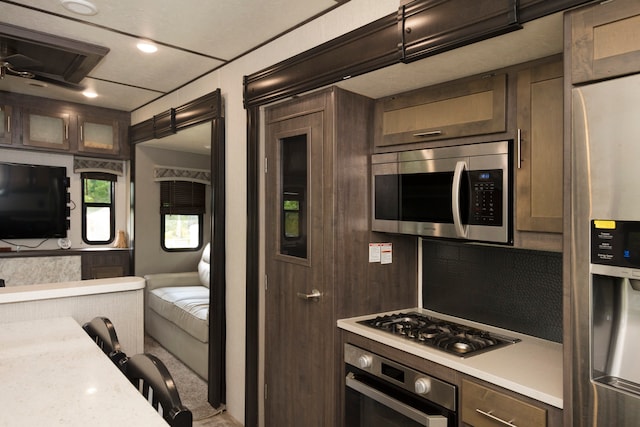 kitchen featuring dark brown cabinetry and appliances with stainless steel finishes