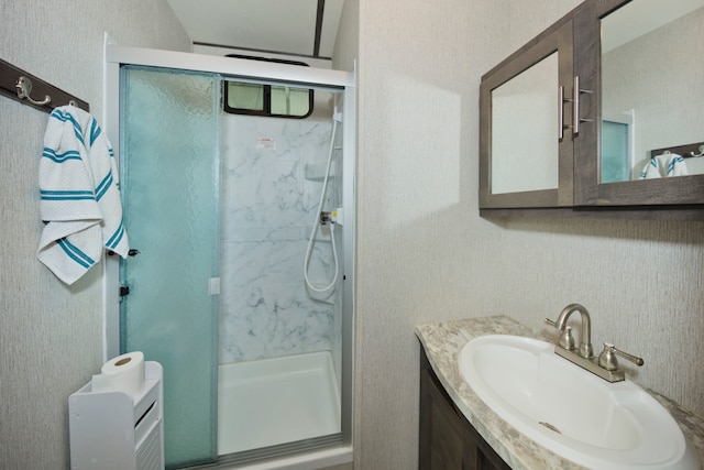 bathroom with vanity and a shower with shower door