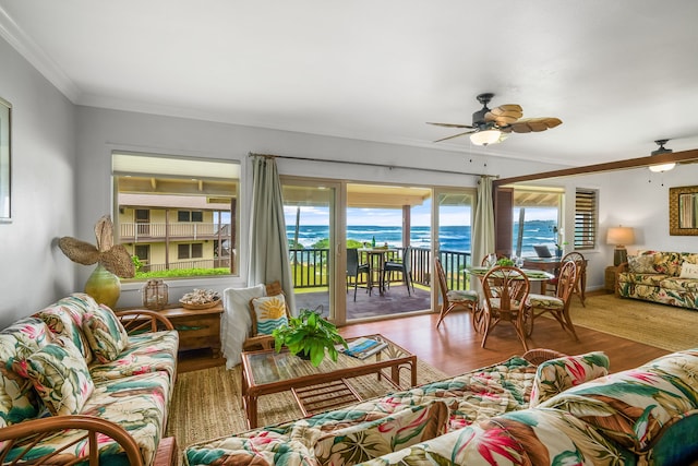 living room with a water view, hardwood / wood-style floors, ceiling fan, and crown molding