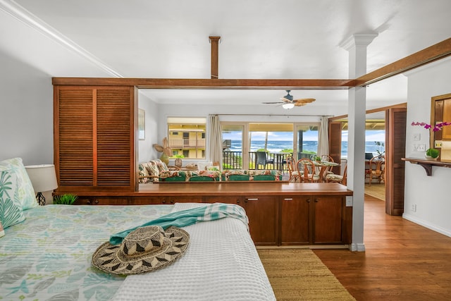 bedroom with hardwood / wood-style flooring, crown molding, access to exterior, and multiple windows