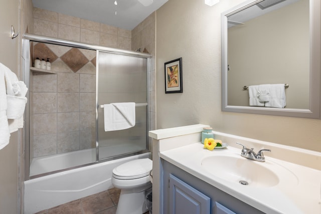 full bathroom with vanity, combined bath / shower with glass door, toilet, and tile patterned floors