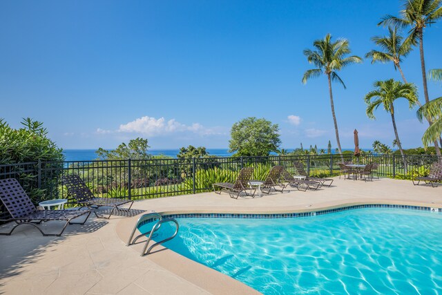 view of swimming pool featuring a patio and a water view