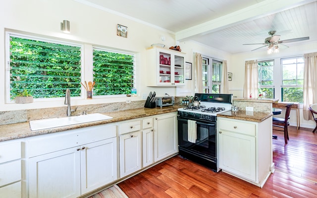 kitchen featuring sink, kitchen peninsula, hardwood / wood-style floors, black range with gas cooktop, and ceiling fan