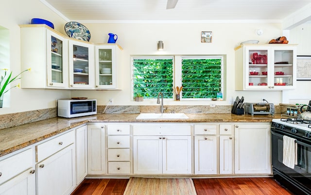 kitchen featuring light stone counters, hardwood / wood-style floors, sink, and gas stove