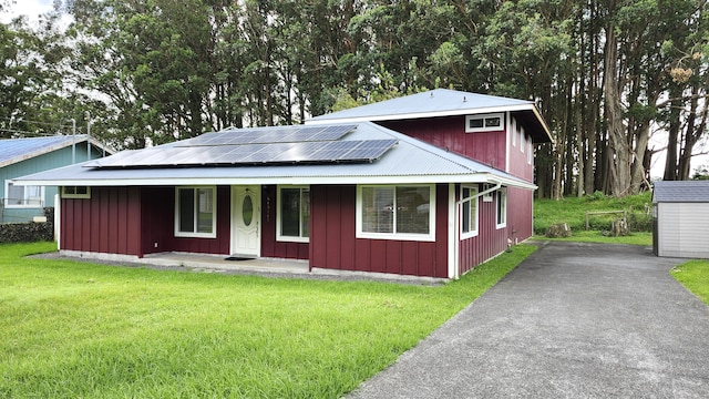 view of front facade featuring a porch, solar panels, and a front lawn