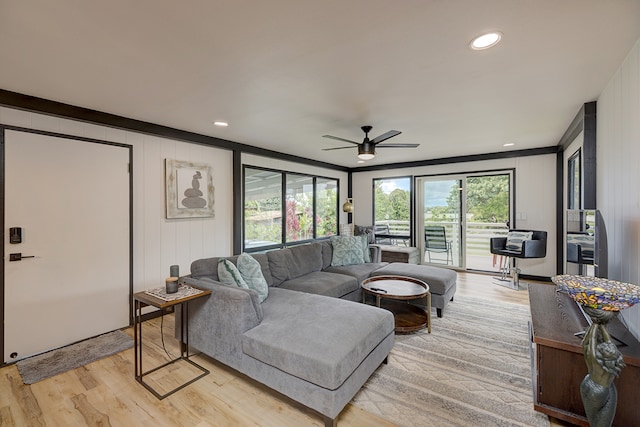 living room featuring light wood-type flooring, ceiling fan, and crown molding