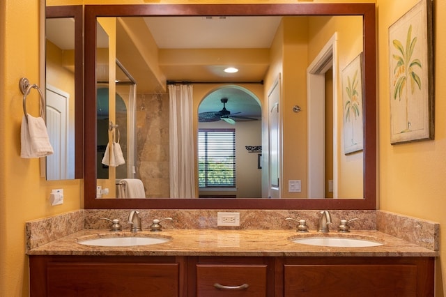 full bath with a sink, walk in shower, and double vanity