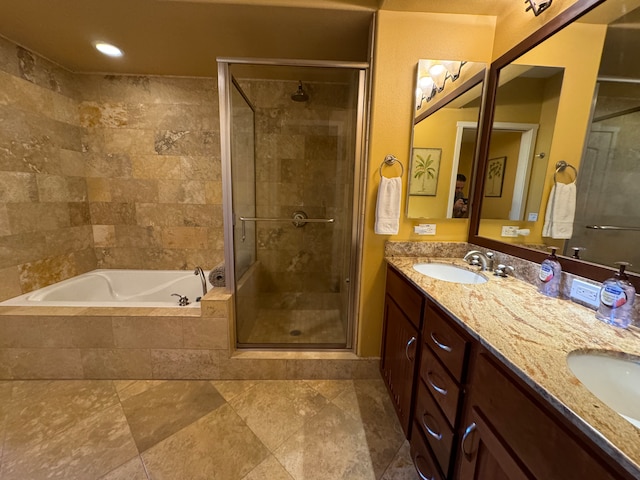 full bathroom with a shower stall, a bath, double vanity, and a sink