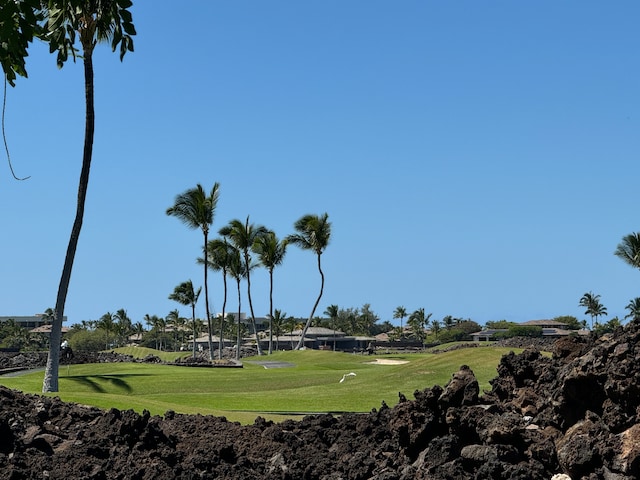 view of community with golf course view and a yard