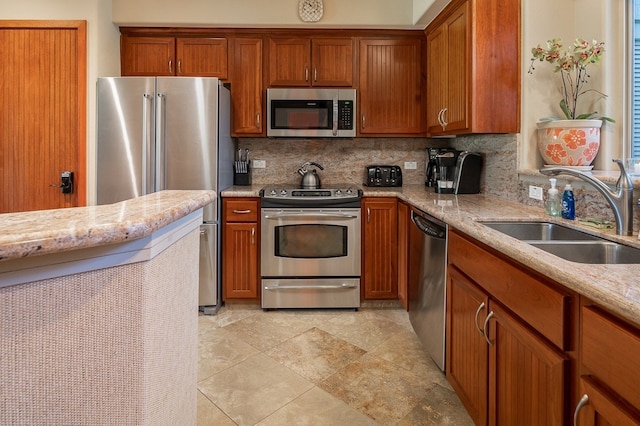 kitchen featuring brown cabinets, stainless steel appliances, and a sink