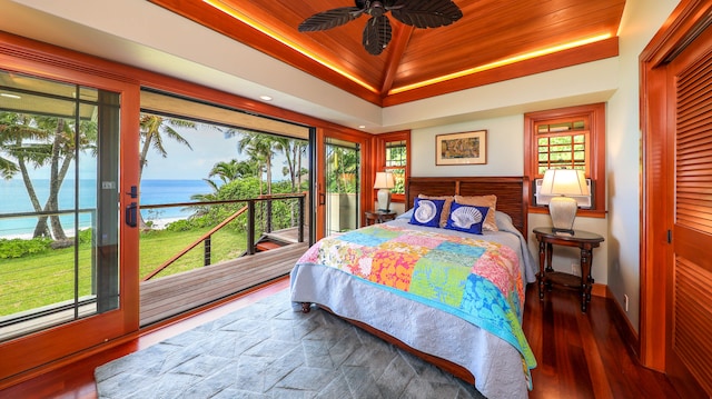 bedroom with ceiling fan, a water view, dark wood-type flooring, and access to outside