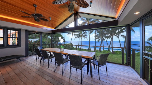 sunroom with ceiling fan, a water view, lofted ceiling, and a wealth of natural light