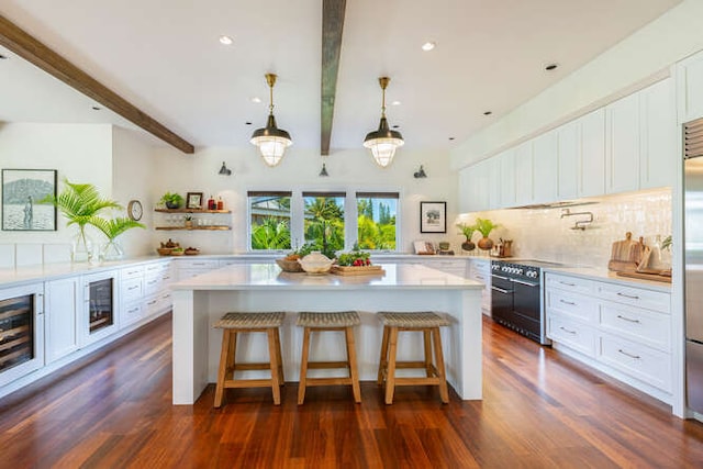 kitchen featuring black range oven, a breakfast bar, dark hardwood / wood-style flooring, beam ceiling, and beverage cooler