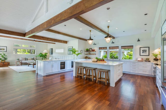 kitchen featuring white cabinetry, a center island, wine cooler, and plenty of natural light