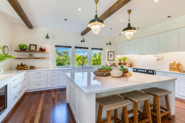 kitchen featuring white cabinets, dark hardwood / wood-style floors, and beam ceiling