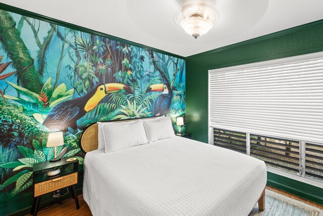 bedroom featuring ceiling fan, hardwood / wood-style flooring, and multiple windows