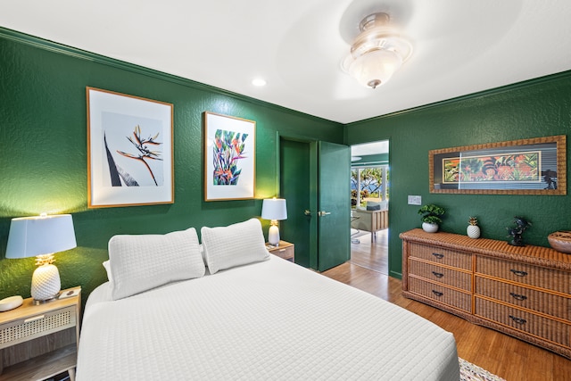 bedroom with ornamental molding and hardwood / wood-style flooring