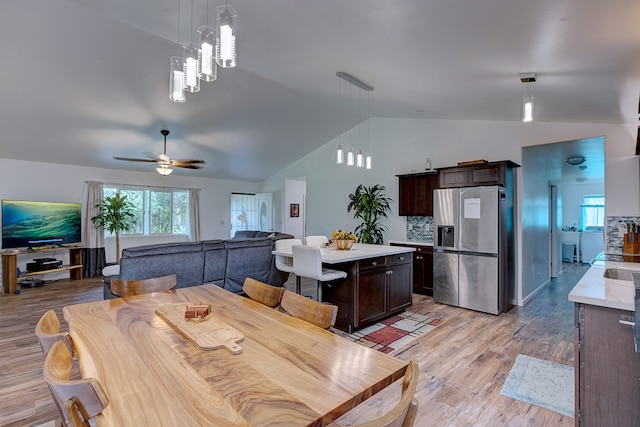 dining area featuring light wood-type flooring, lofted ceiling, and ceiling fan