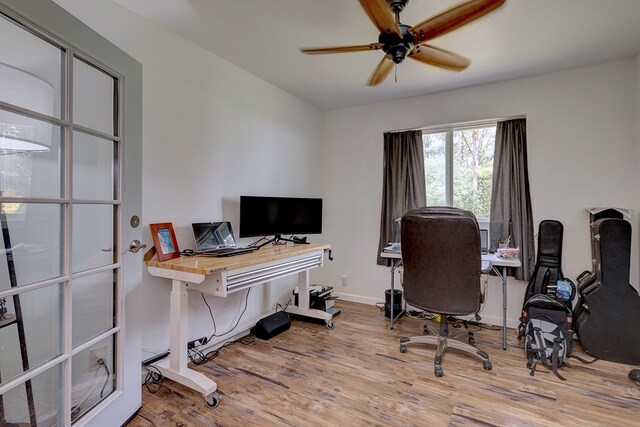 home office with ceiling fan and light wood-type flooring