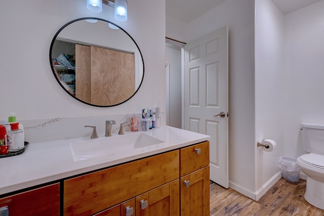 bathroom with wood-type flooring, vanity, and toilet