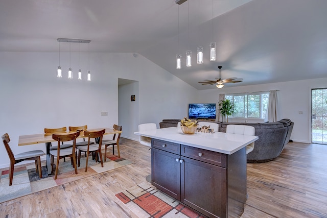 kitchen with ceiling fan, decorative light fixtures, lofted ceiling, and light hardwood / wood-style flooring