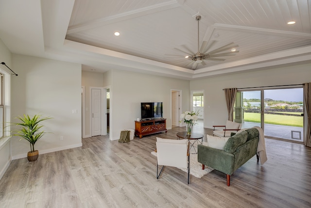 living room with a raised ceiling, high vaulted ceiling, light wood-type flooring, and ceiling fan