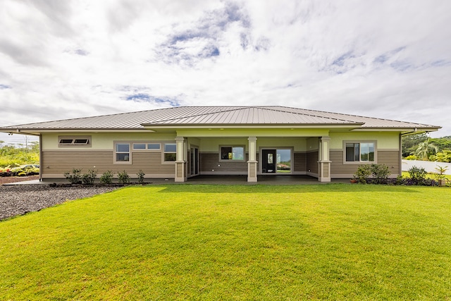 rear view of house featuring a lawn