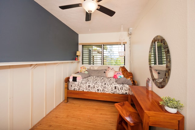 bedroom featuring ceiling fan, light hardwood / wood-style flooring, and lofted ceiling