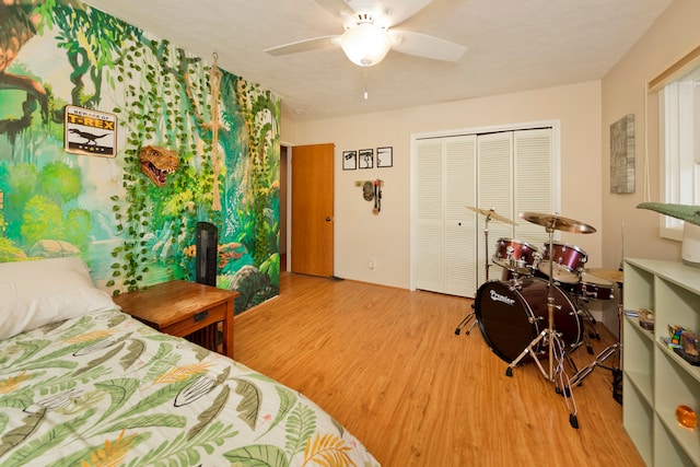 bedroom featuring a textured ceiling, ceiling fan, light hardwood / wood-style flooring, and a closet