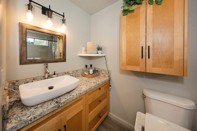 bathroom with hardwood / wood-style floors, vanity, and toilet