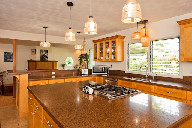 kitchen featuring a kitchen breakfast bar, hanging light fixtures, stainless steel appliances, a center island, and sink