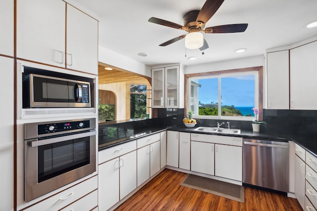 kitchen featuring stainless steel appliances, white cabinetry, and sink