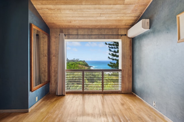 empty room with a wall mounted AC, wooden ceiling, vaulted ceiling, and hardwood / wood-style flooring