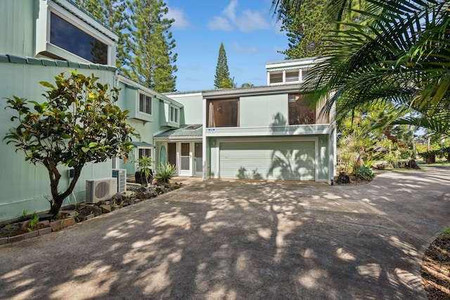 view of front of house with ac unit and a garage