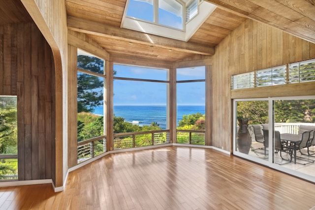 unfurnished sunroom with vaulted ceiling with skylight, a water view, and wood ceiling