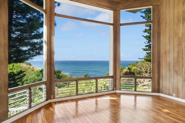 unfurnished sunroom featuring a water view