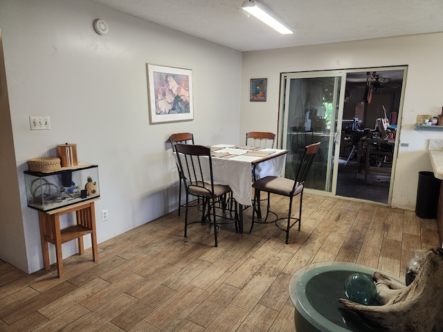 dining area featuring wood-type flooring and a textured ceiling