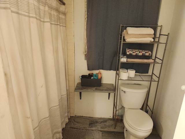 bathroom featuring tile patterned flooring, walk in shower, and toilet