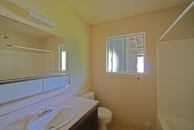 full bathroom with vanity, a textured ceiling, washtub / shower combination, and toilet