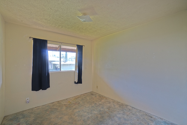 carpeted spare room with a textured ceiling