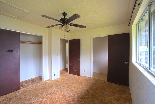 unfurnished bedroom featuring ceiling fan, a textured ceiling, and light carpet